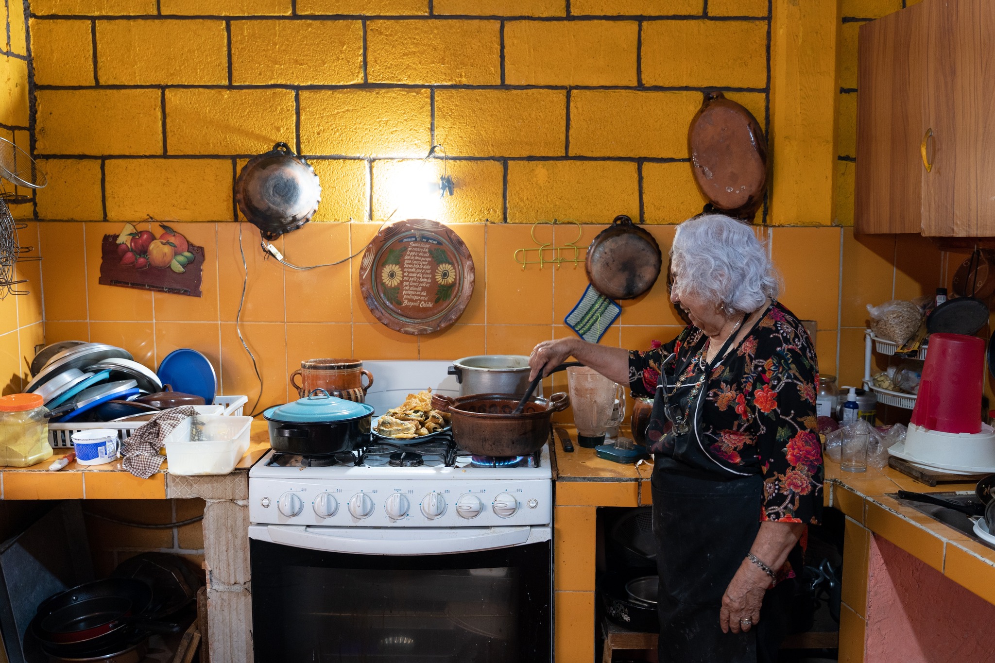 A happy senior woman cooking at home.