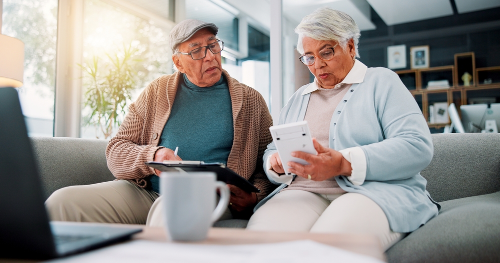 Two seniors financially planning in their living room.
