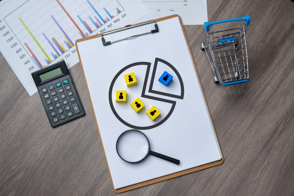 An image of a clipboard with a pie chart and colored blocks on it.
