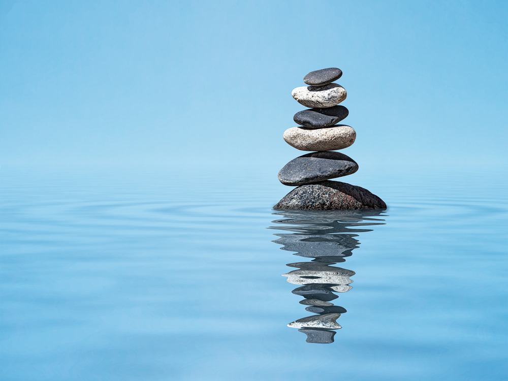Rocks balanced on top of each other in a pool of water.