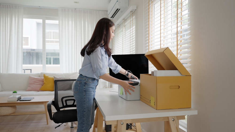A woman organizing her workspace in an apartment.