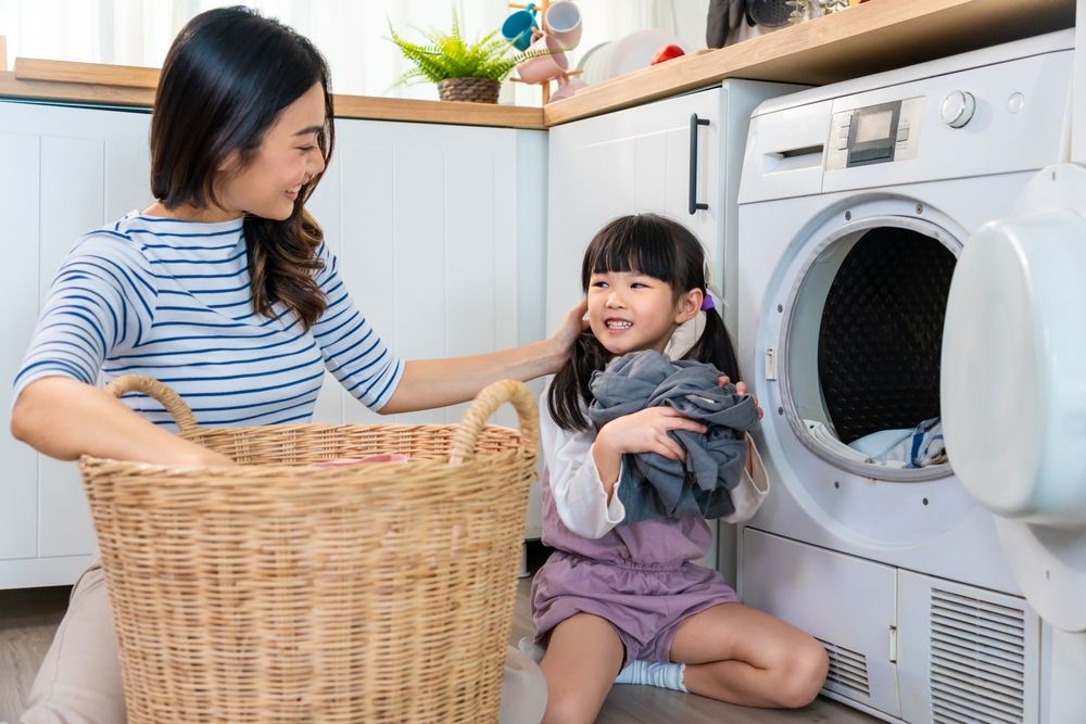 A child helping her mom with the laundry.