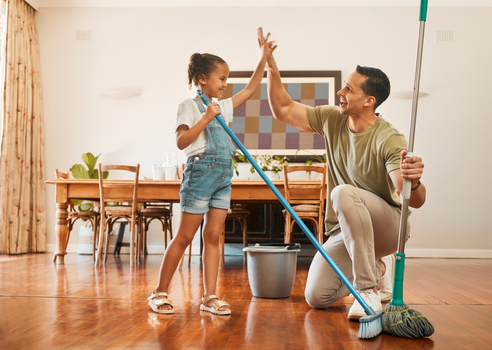 A father high fiving his daughter after finishing cleaning. 