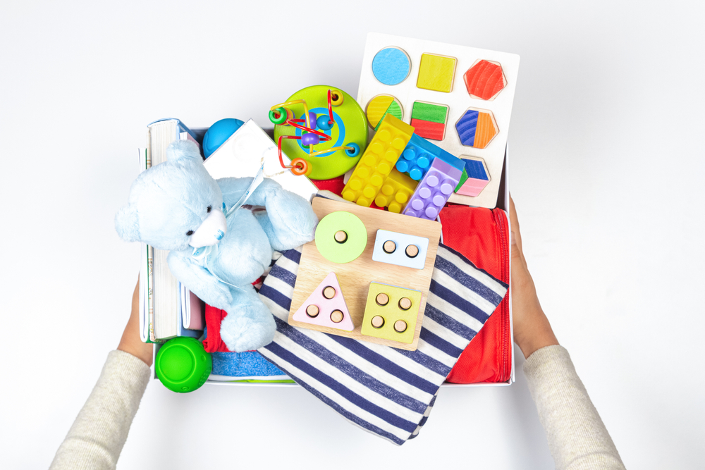 Hands holding a box of toys for donations.