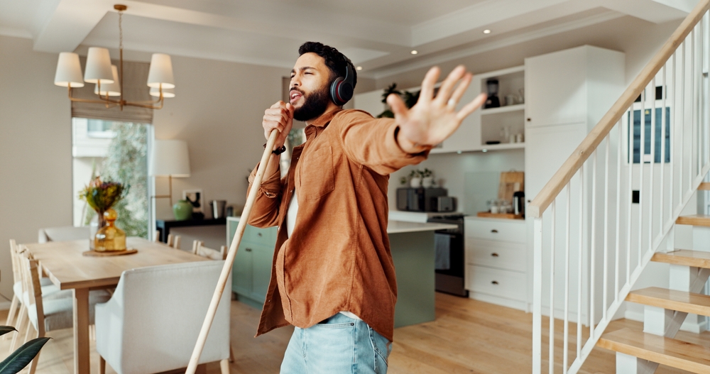 An image of a man dancing while sweeping the floor with a broom.