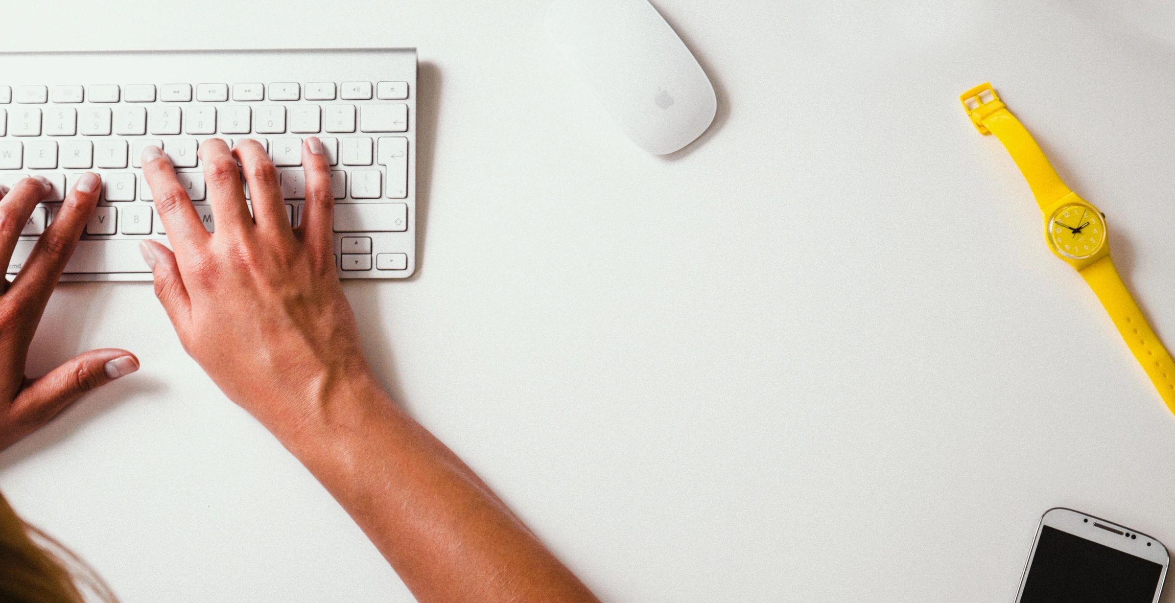 A close-up image of a pair of hands typing on a computer keyboard to reduce digital clutter.