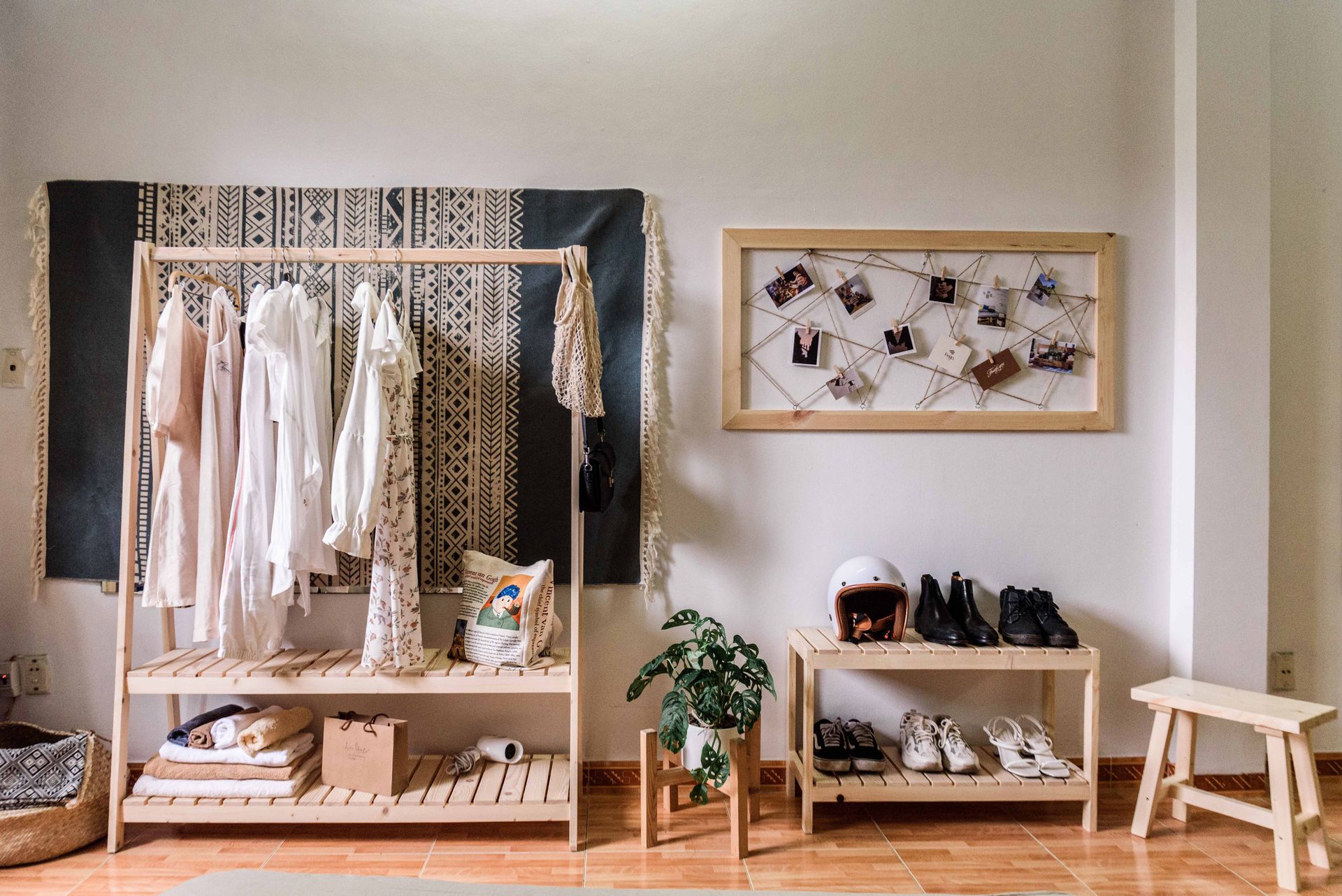 An image of shoes and clothes organized using a hanger rack and shelf.