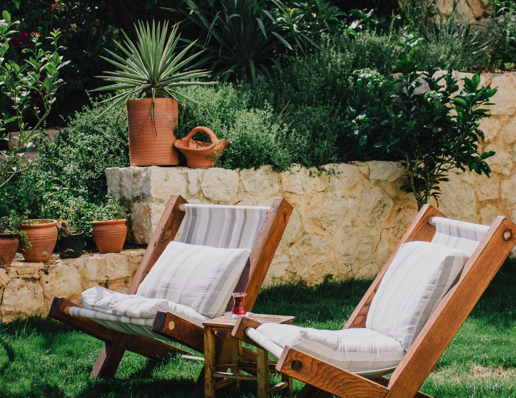 An image of two yard chairs on a small lawn.