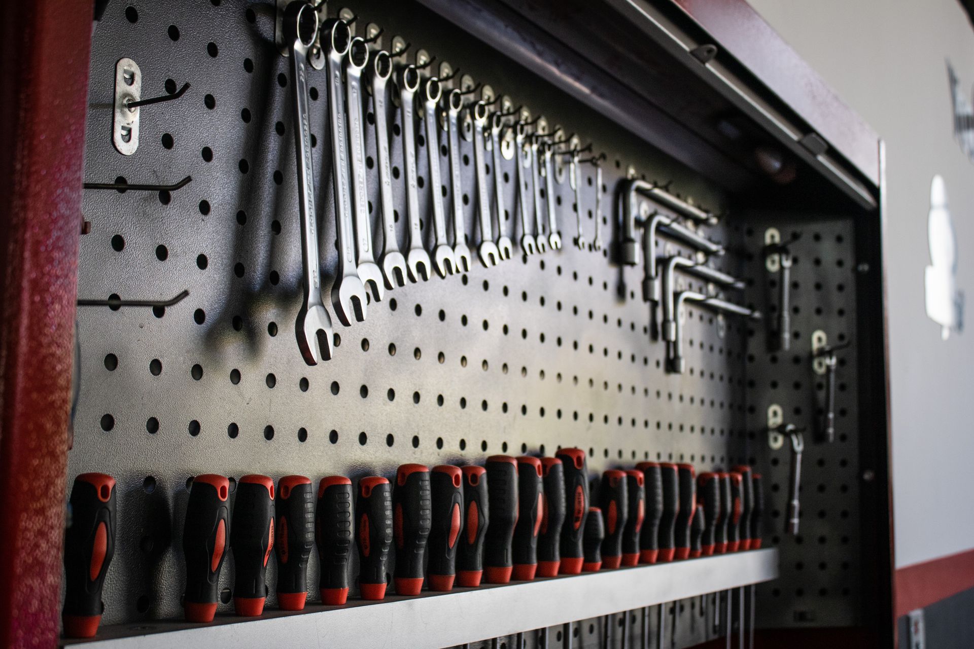 An image of a set of tools easily accessible on a peg board.