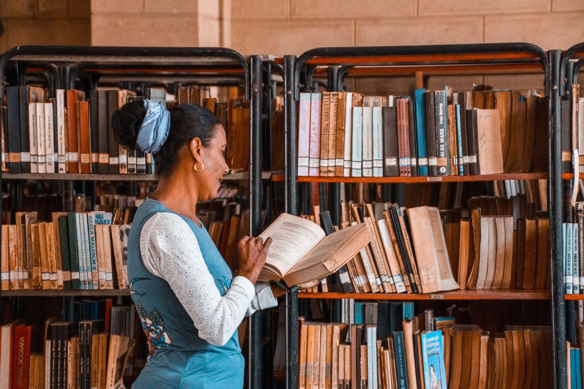 An image of a woman researching using a book at a library.
