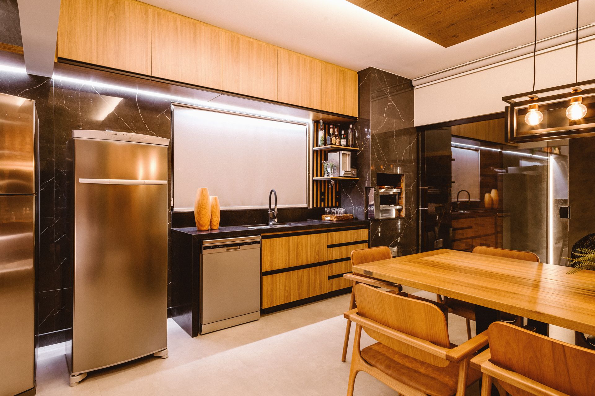 An image of a modern kitchen with warm lighting and wood finish.