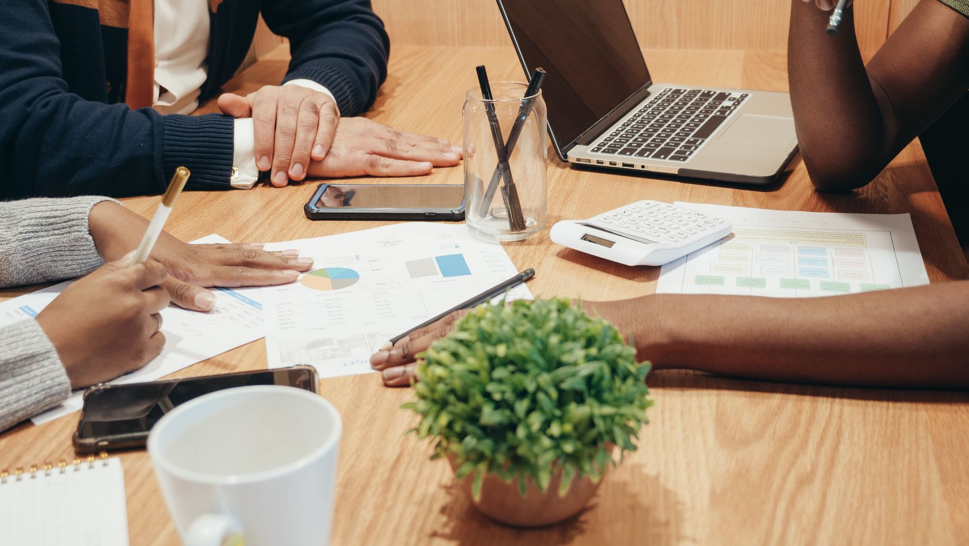 An image of a group of people having a business meeting at a desk.